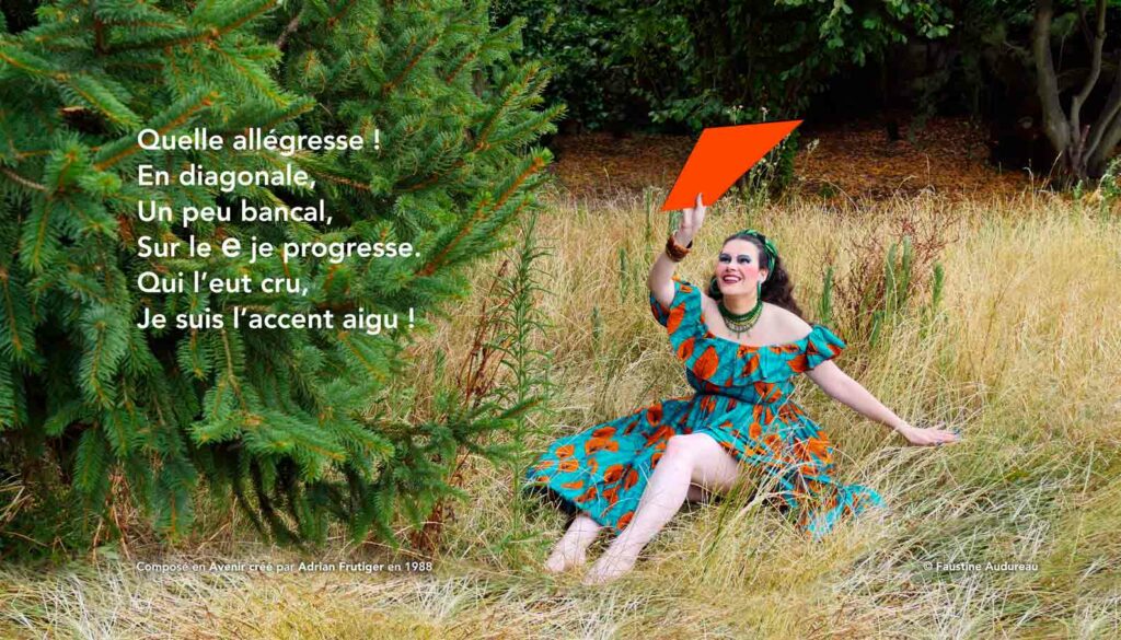 La photographie couleur est scindée en deux parties. À gauche de l’image : un sapin. À droite, une femme aux longs cheveux noirs est assise sur un sol encombré de hautes herbes sèches. Elle porte une longue robe verte et orange en wax créée par Gaëlle Prudencio pour Ibilola. Son bustier a un volant et de la fente entrouverte du bas de la robe on voit sa jambe. La femme porte un foulard dans les cheveux, des boucles d’oreilles et des colliers verts. De sa main droite elle tient au dessus de sa tête un grand accent aigu du même orange que le motif de feuille de la robe. À la gauche de l’image, le texte blanc est composé en Benguiat, créé par le typographe Edward Benguiat : « Quelle allégresse ! En diagonale, un peu bancal, sur le e je progresse. Qui l'eut cru, je suis l'accent aigu ! ».