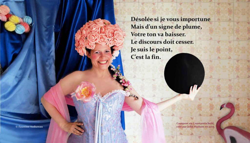 Sur la photographie couleur, une femme de face sourit de toutes ses dents. Elle est très maquillée et porte sur la tête une coiffure composée de roses rose pâle en plastique. Elle est habillée d’un corset bleu et rose à motifs et une fleur rose et jaune est accrochée à sa poitrine. Autour de ses bras flottent une étole rose translucide. Sa main droite est posée sur sa hanche. Elle tient de la main gauche un grand point noir en volume. Des tissus bleus et une guirlande de papiers de couleurs sont accrochés derrière elle. En bas à droite de la photographie est posé un flamand rose contre des carreaux en faïence aux motifs blanc et rose. Le texte noir placé à droite sur l’image est composé en Constantia bold, créé par le typographe John Hudson : « Désolée si je vous importune mais d’un signe de plume, votre ton va baisser. Le discours doit cesser. Je suis le point, c’est la fin. »